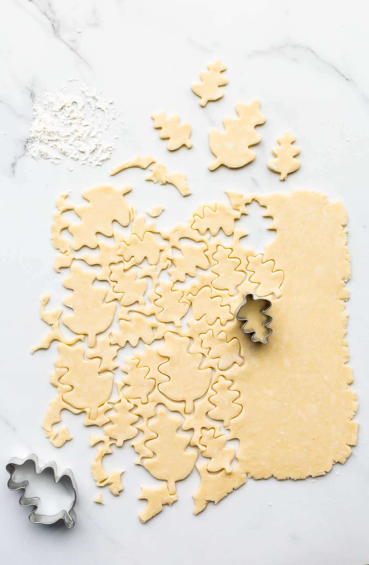 Cutting out pie crust cookies from leftover pie dough. These can be baked to eat as cookies or used to decorate a pumpkin pie.