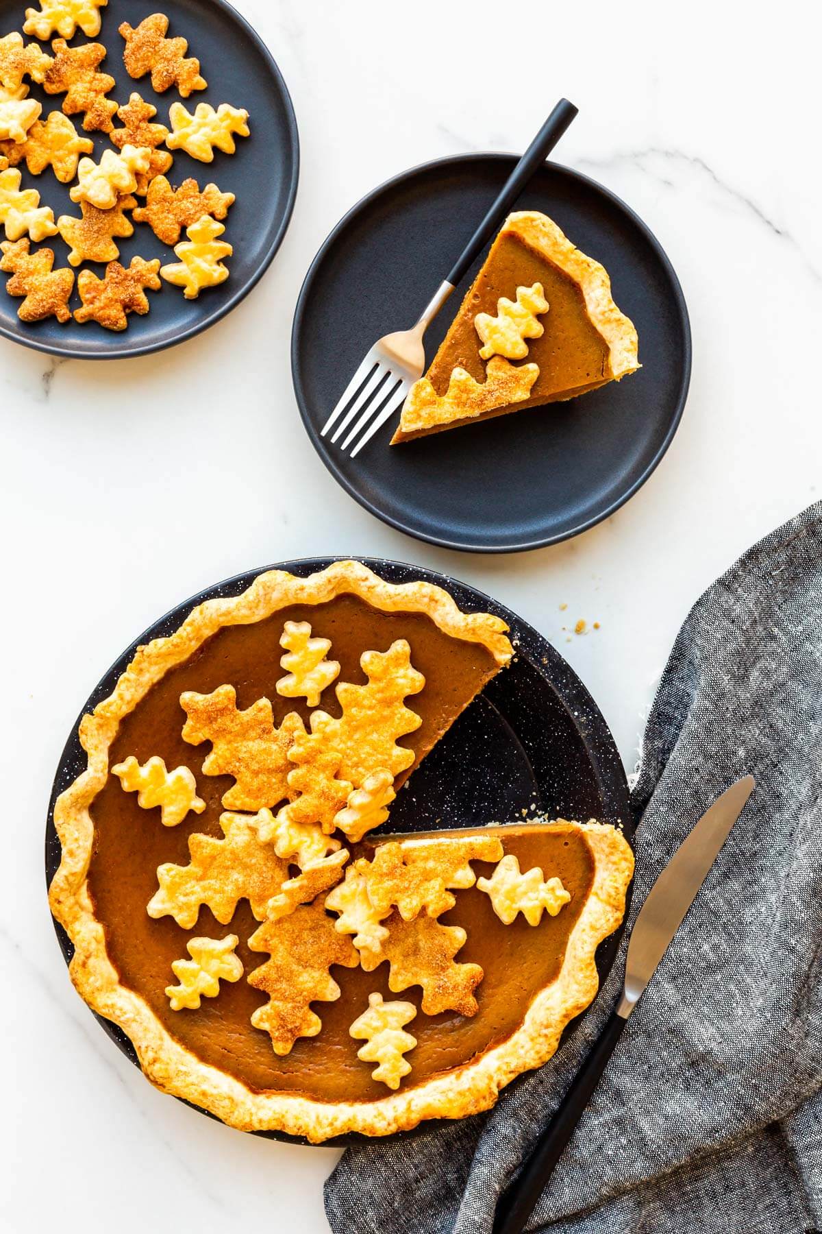 Serving pumpkin pie on black plates.