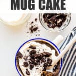 Oreo mug cake topped with whipped cream and crushed Oreo cookies.