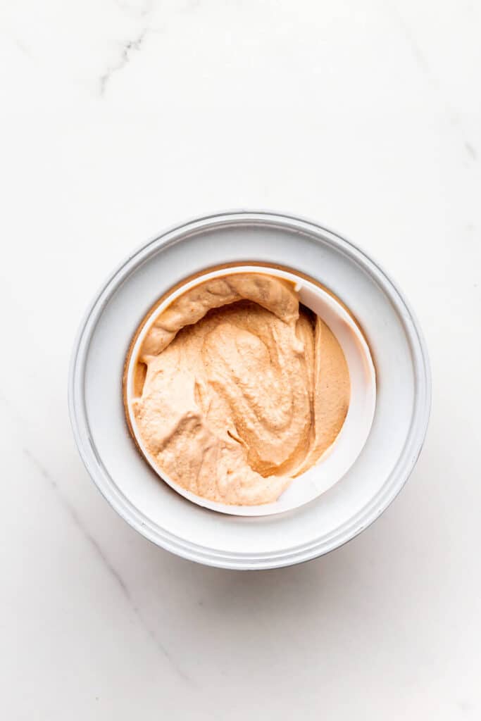 Freshly churned pumpkin ice cream in a freezer drum.