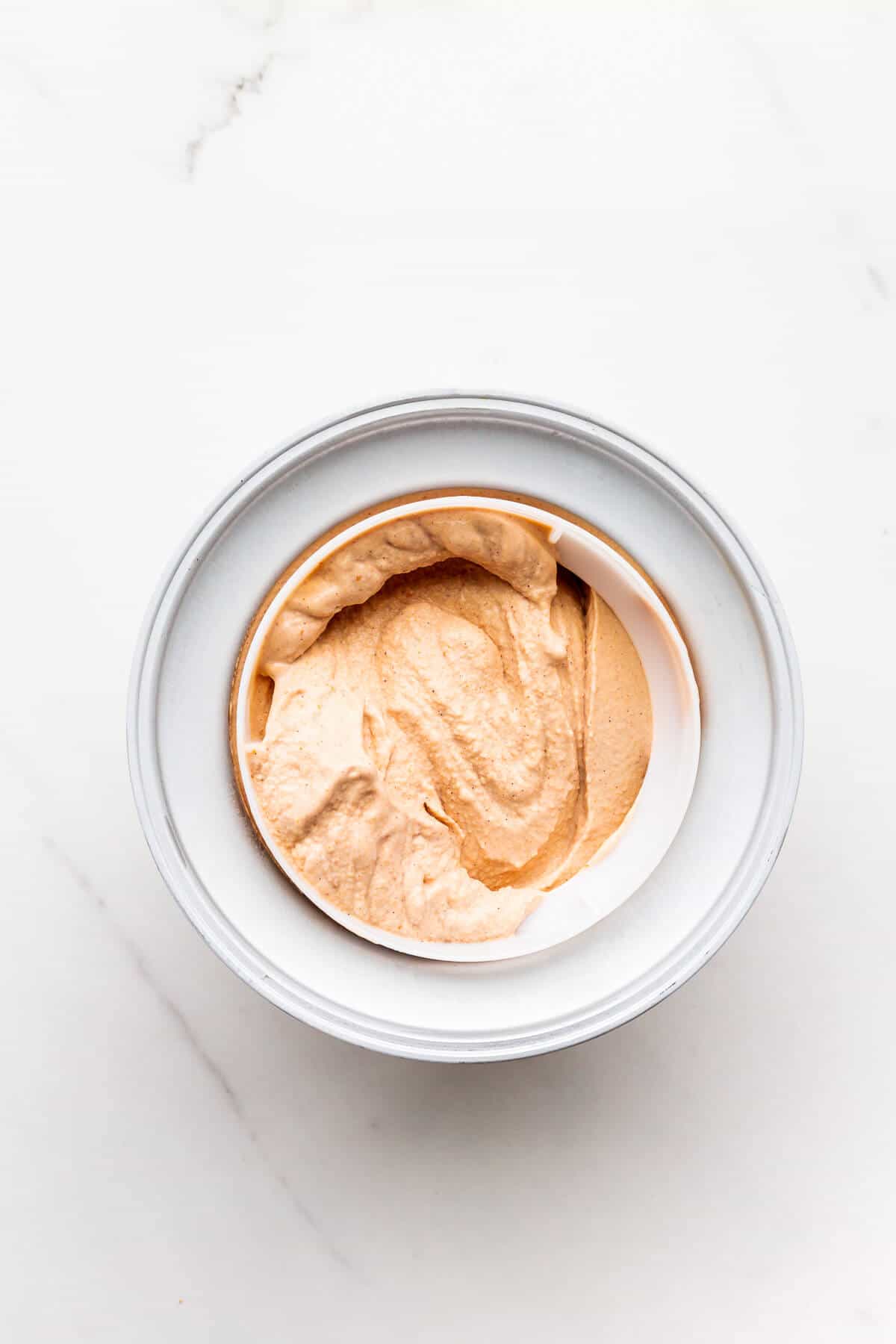 Freshly churned pumpkin ice cream in a freezer drum.