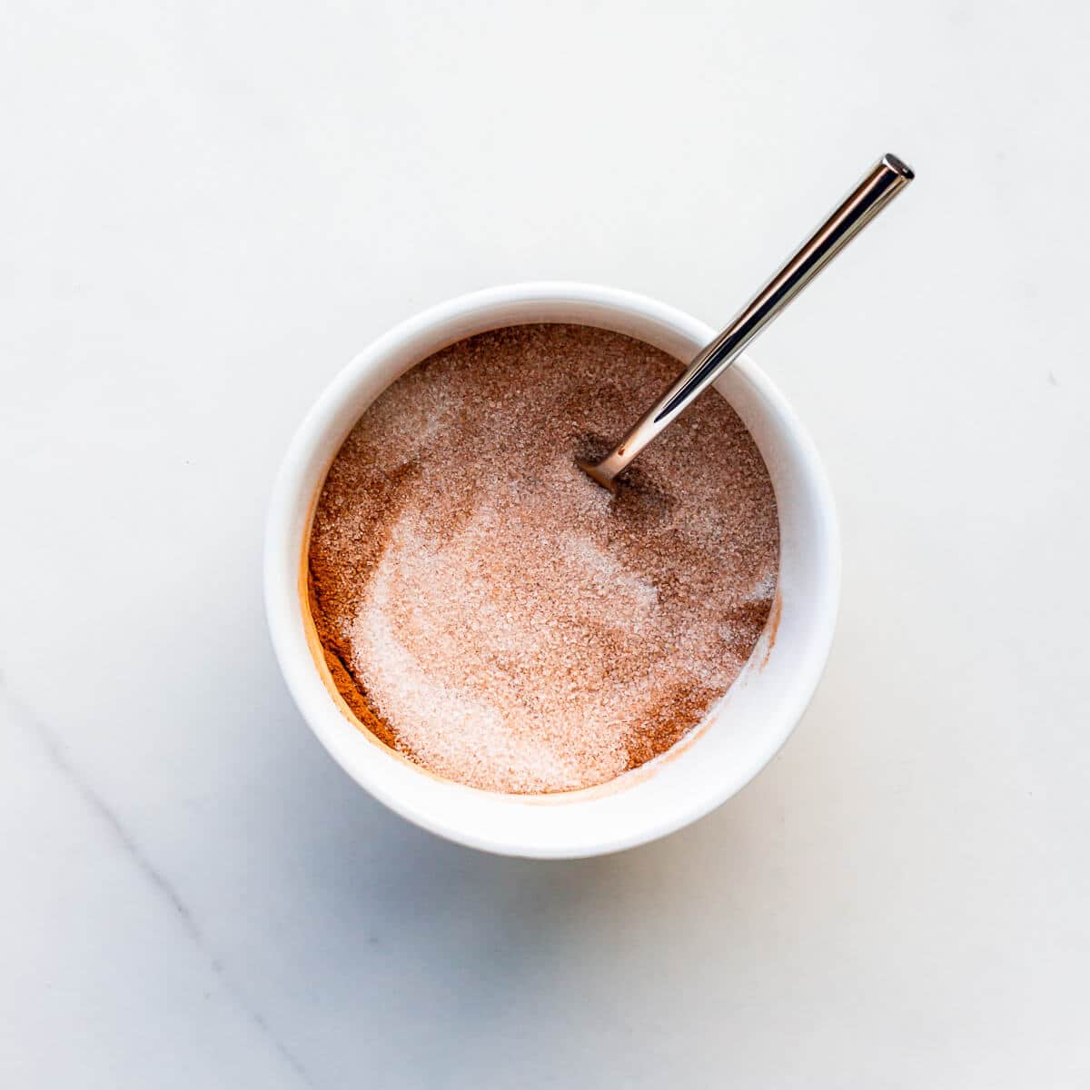 Mixing cinnamon with sugar to make cinnamon sugar.