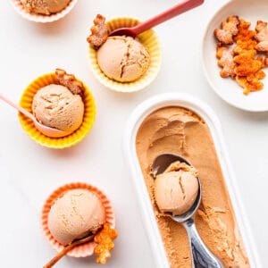 Scoops of pumpkin ice cream in little bowls with pie crust cookies.