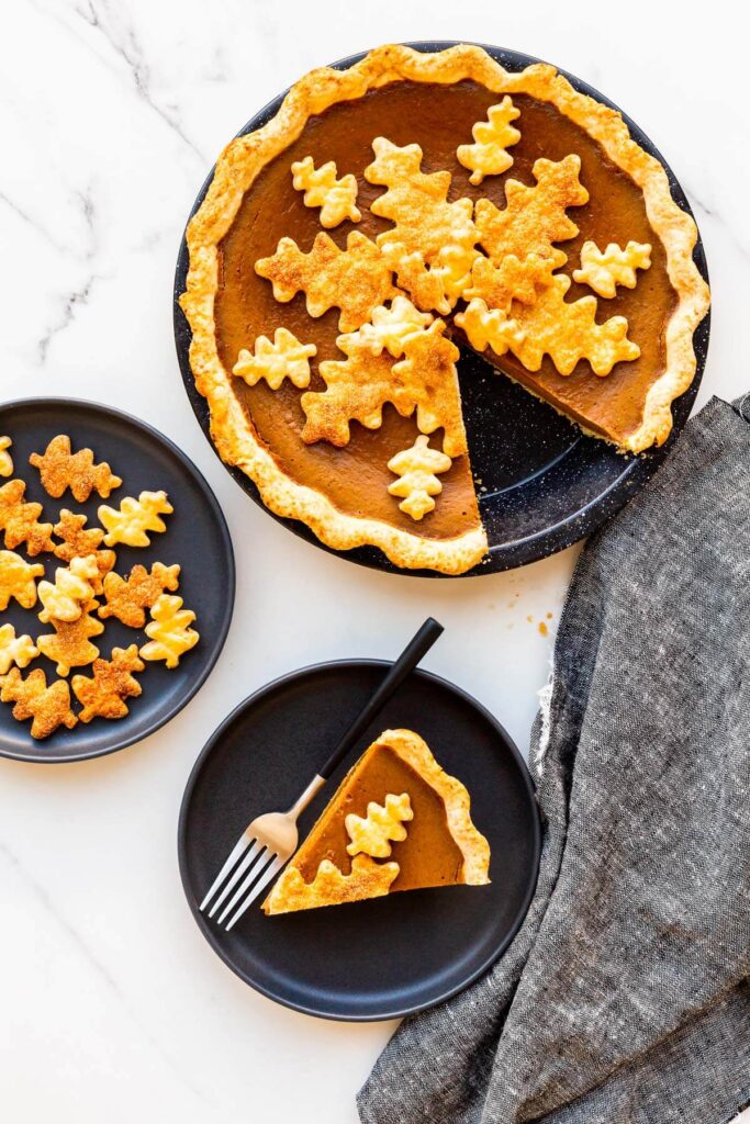 Serving pumpkin pie on black plates.