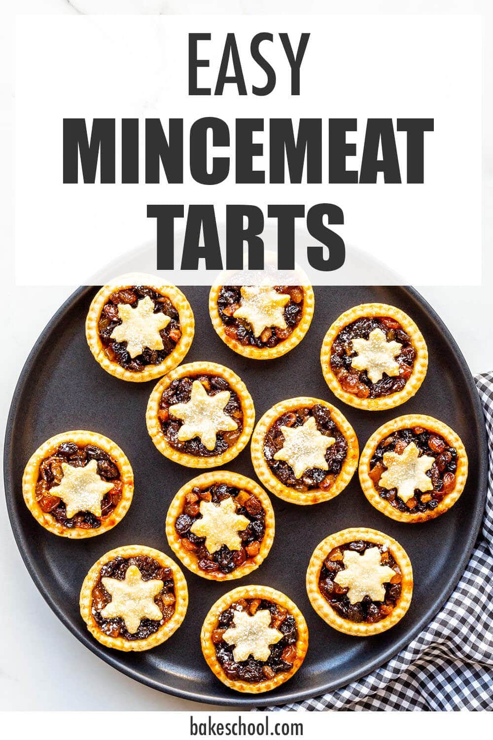 Homemade mincemeat tarts on a black plate, ready to be served.