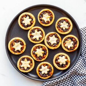 Homemade mincemeat pies on a black plate, ready to be served.