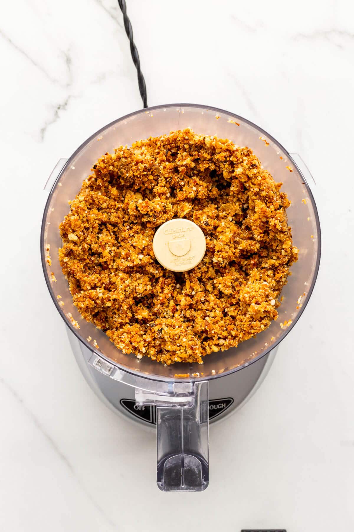 Grinding up leftover fruitcake with rum to make Christmas cake balls.