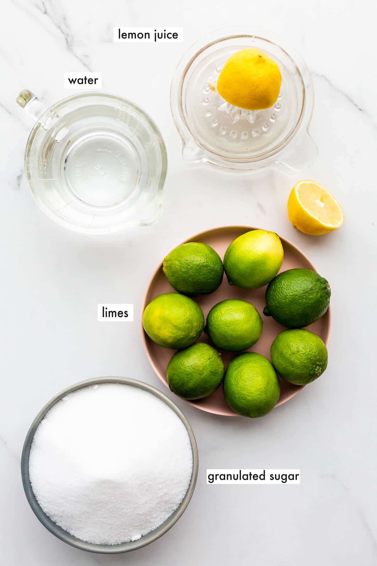 Ingredients to make lime marmalade from whole limes with just granulated sugar, water, and lemon juice, and no pectin added.