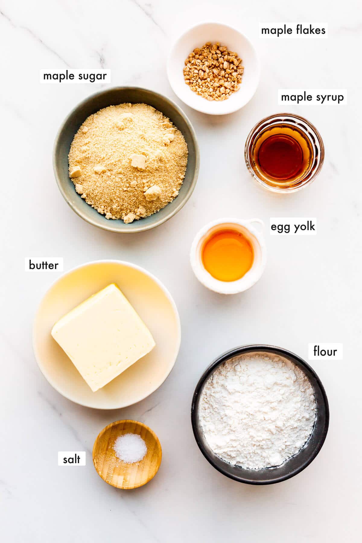 Ingredients to make maple shortbread cookies from scratch with real maple syrup, maple sugar, and maple flakes.