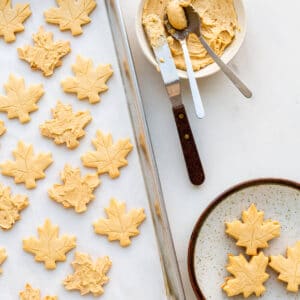 Spreading maple butter filling on maple shortbread to sandwich together and make maple cream cookies.