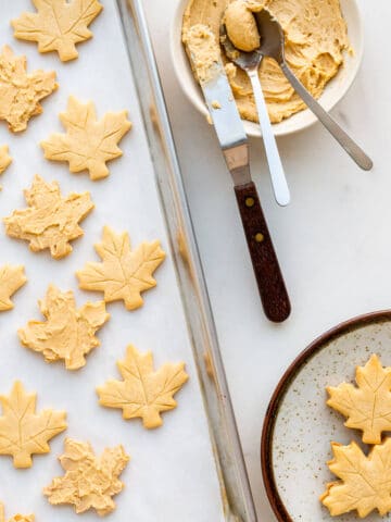 Spreading maple butter filling on maple shortbread to sandwich together and make maple cream cookies.