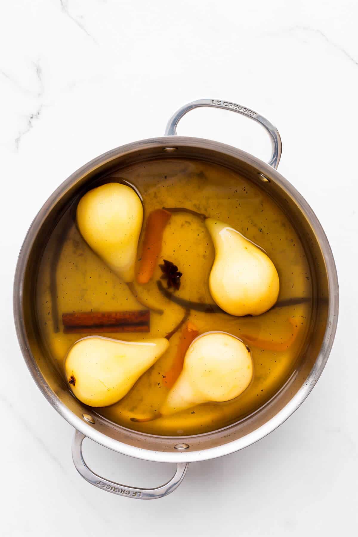 Poached pears in a pot, ready to be served.