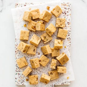 Maple fudge with walnuts, cut into squares, on a platter.