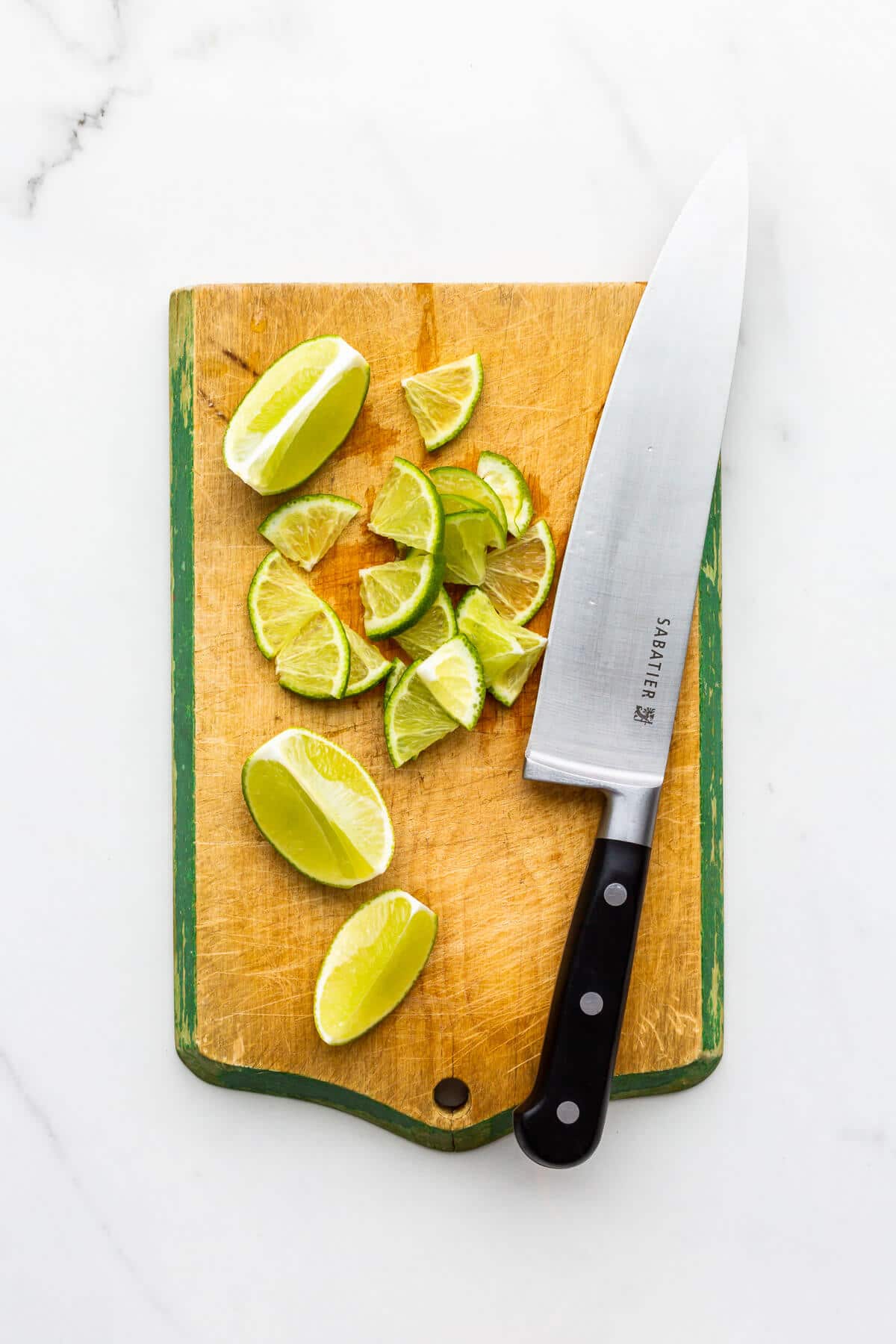 Thinly slicing limes to make lime marmalade.