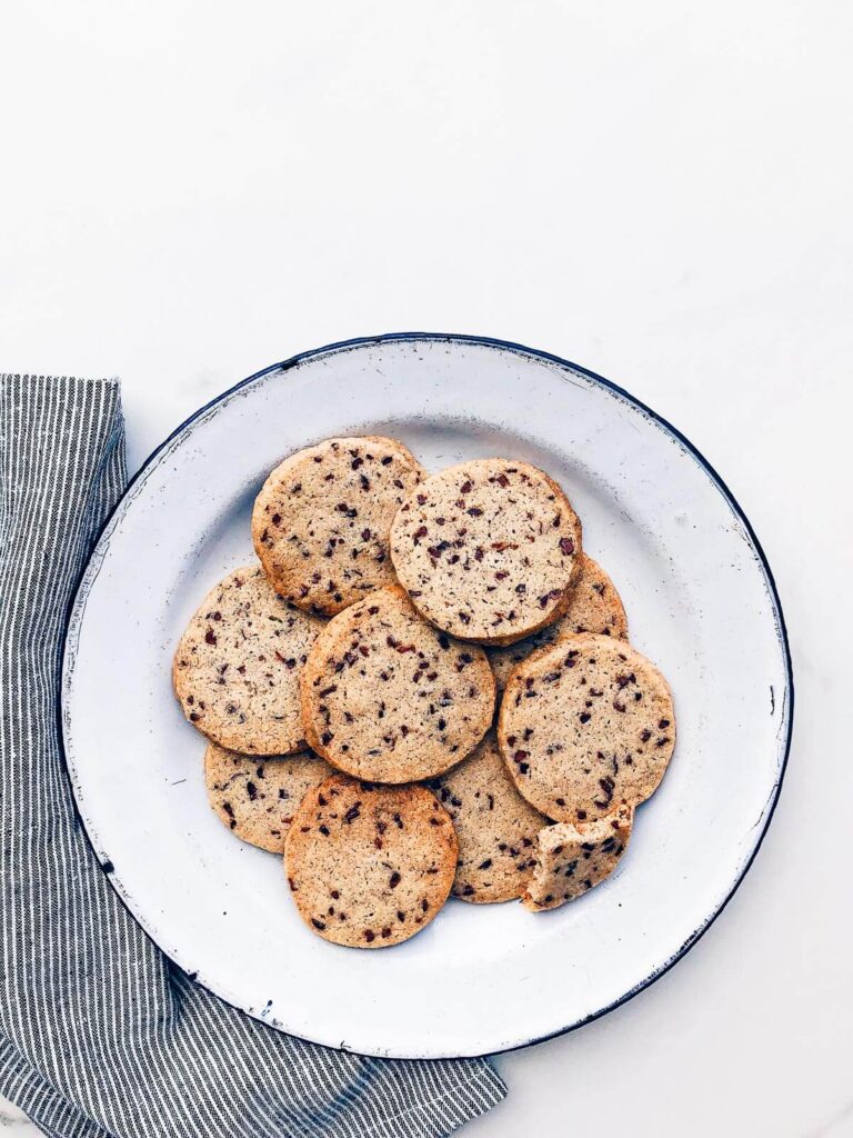 A plate of shortbread cookies with flecks of cocoa nibs.