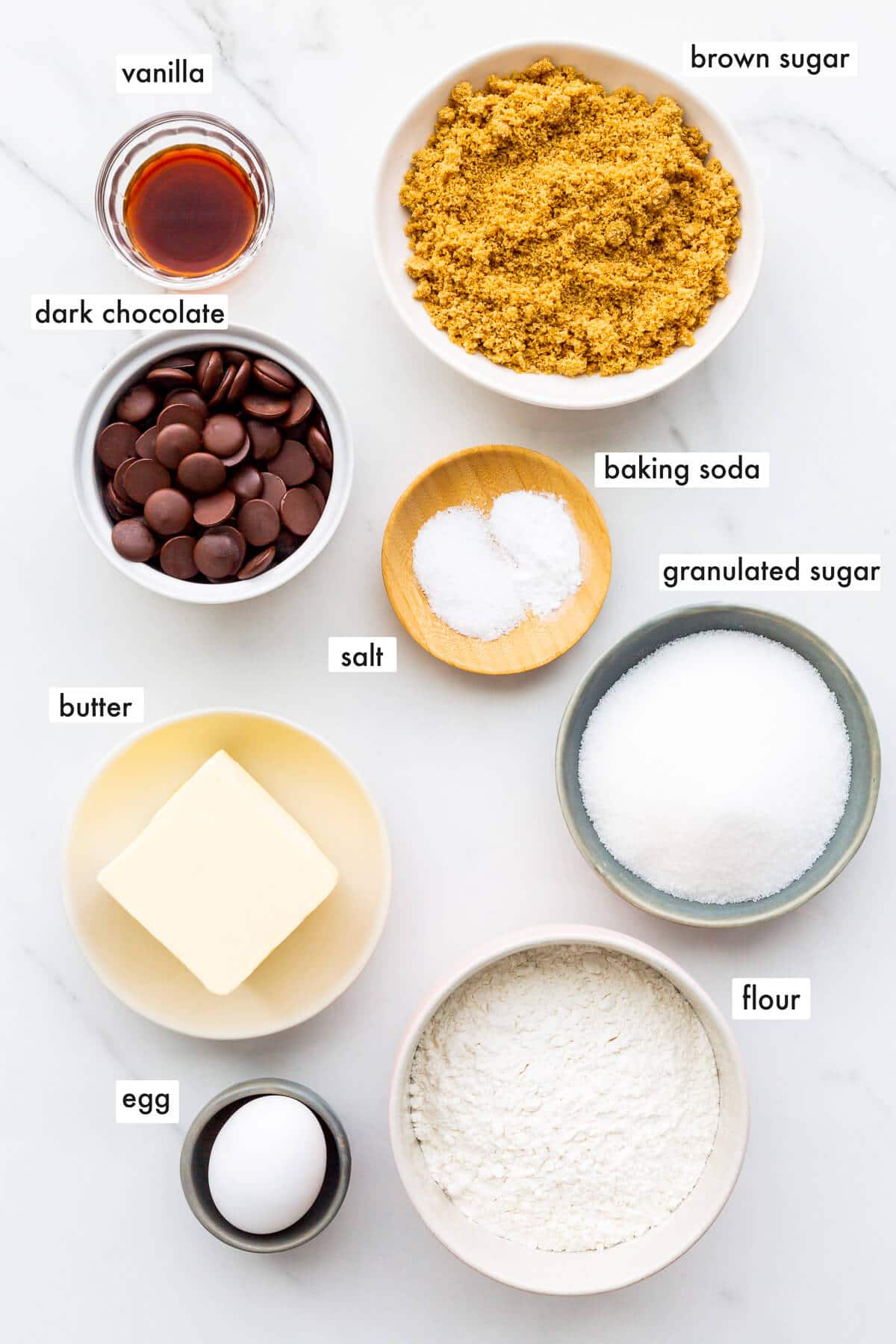 Ingredients to make chocolate chip cookies measured into bowls and ready to bake.