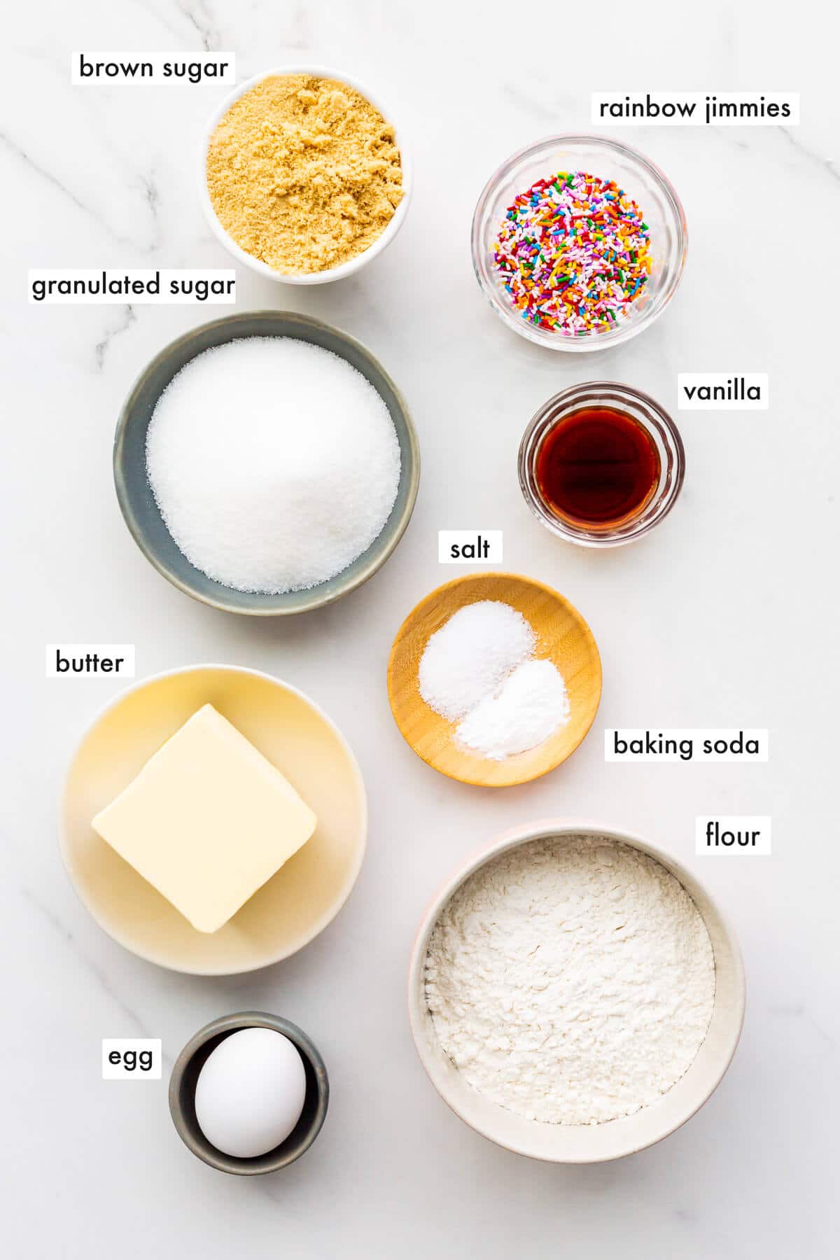 Ingredients to make sugar cookies with sprinkles, measured out into bowls and ready to bake.