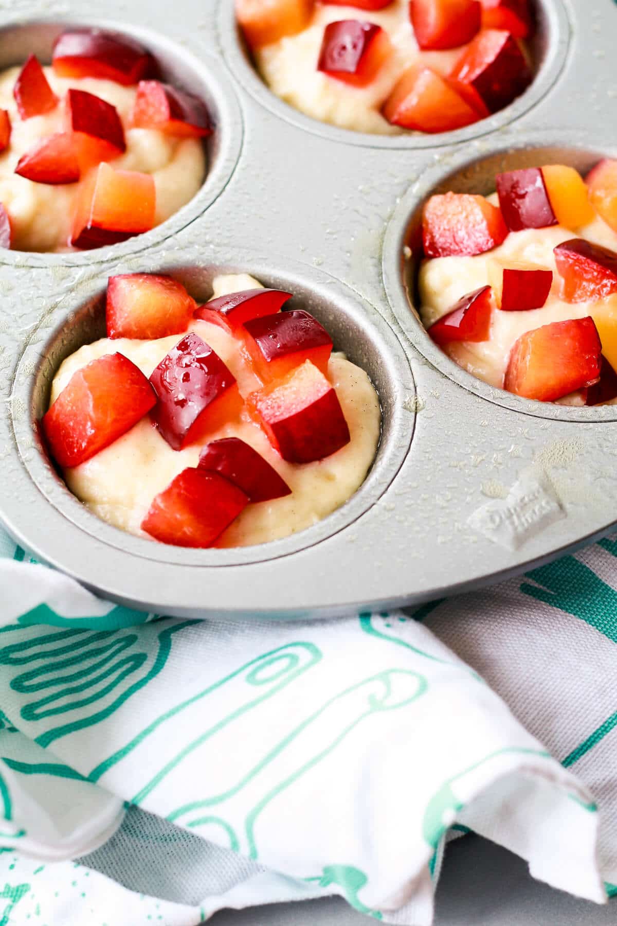 Plum muffins before baking in a muffin pan.