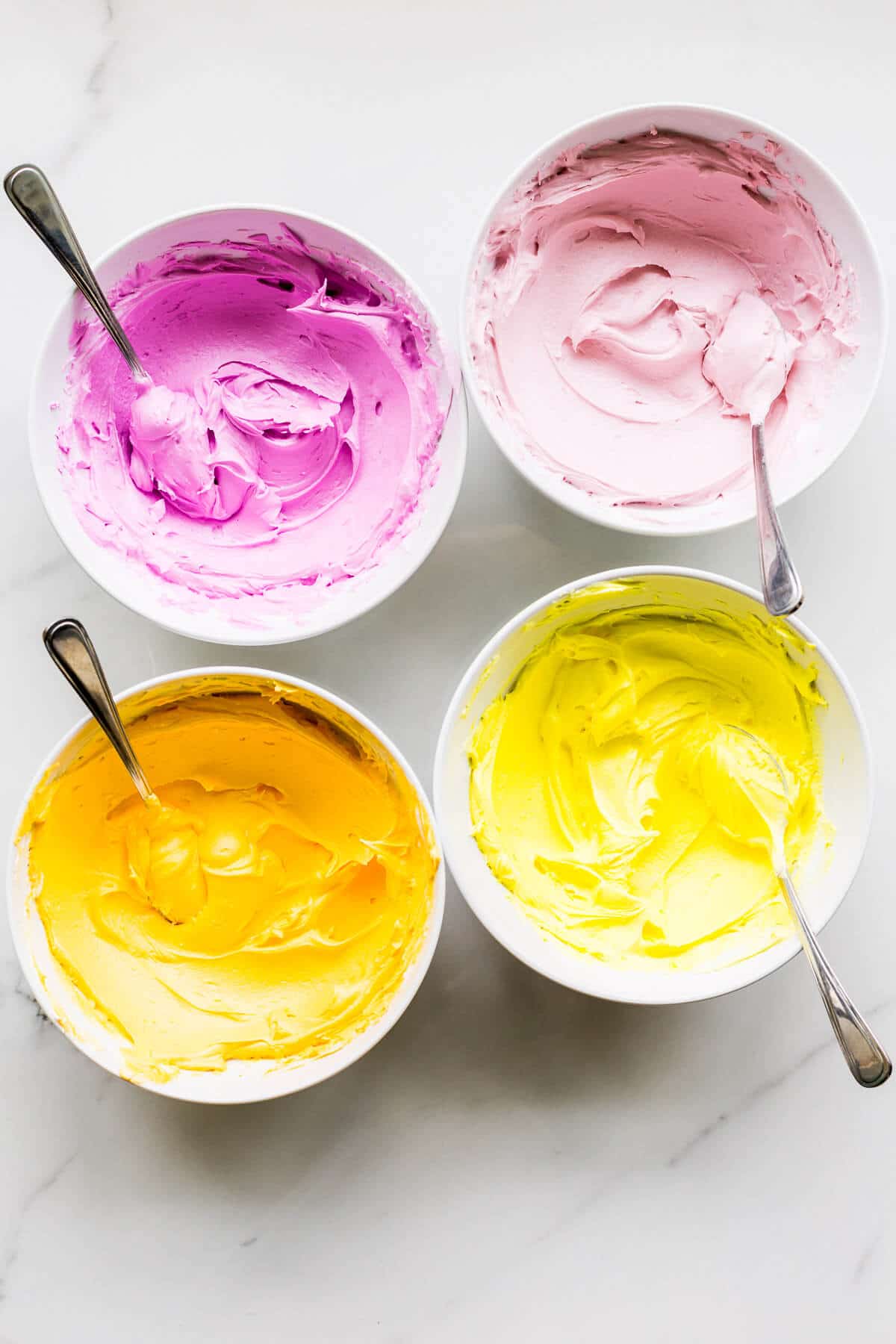 Bowls of royal icing dyed with gel colours to make homemade sprinkles.