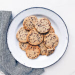 A plate of shortbread cookies with flecks of cocoa nibs.