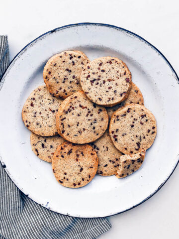 A plate of shortbread cookies with flecks of cocoa nibs.