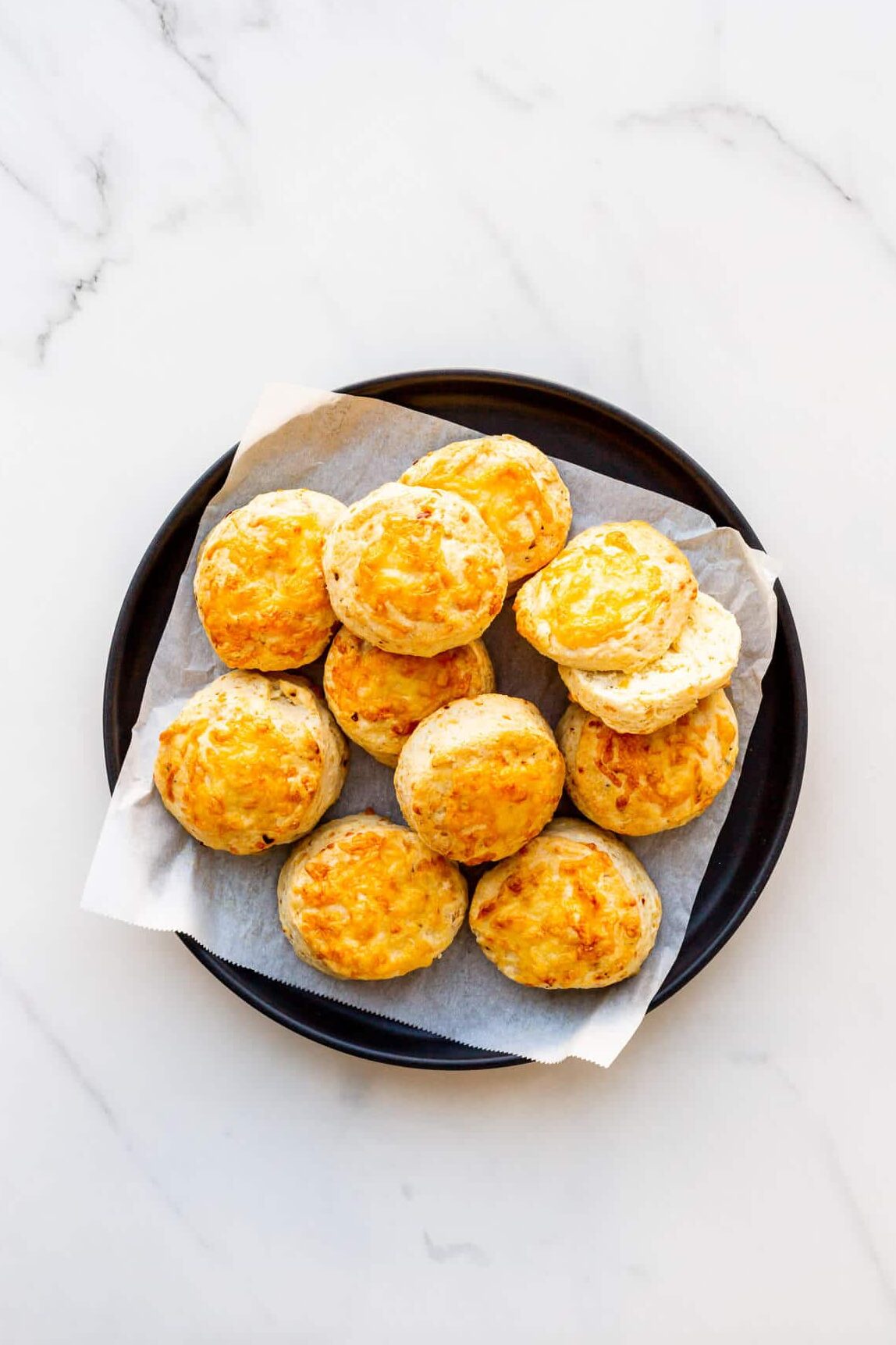 A plate of scones topped with melted cheese.