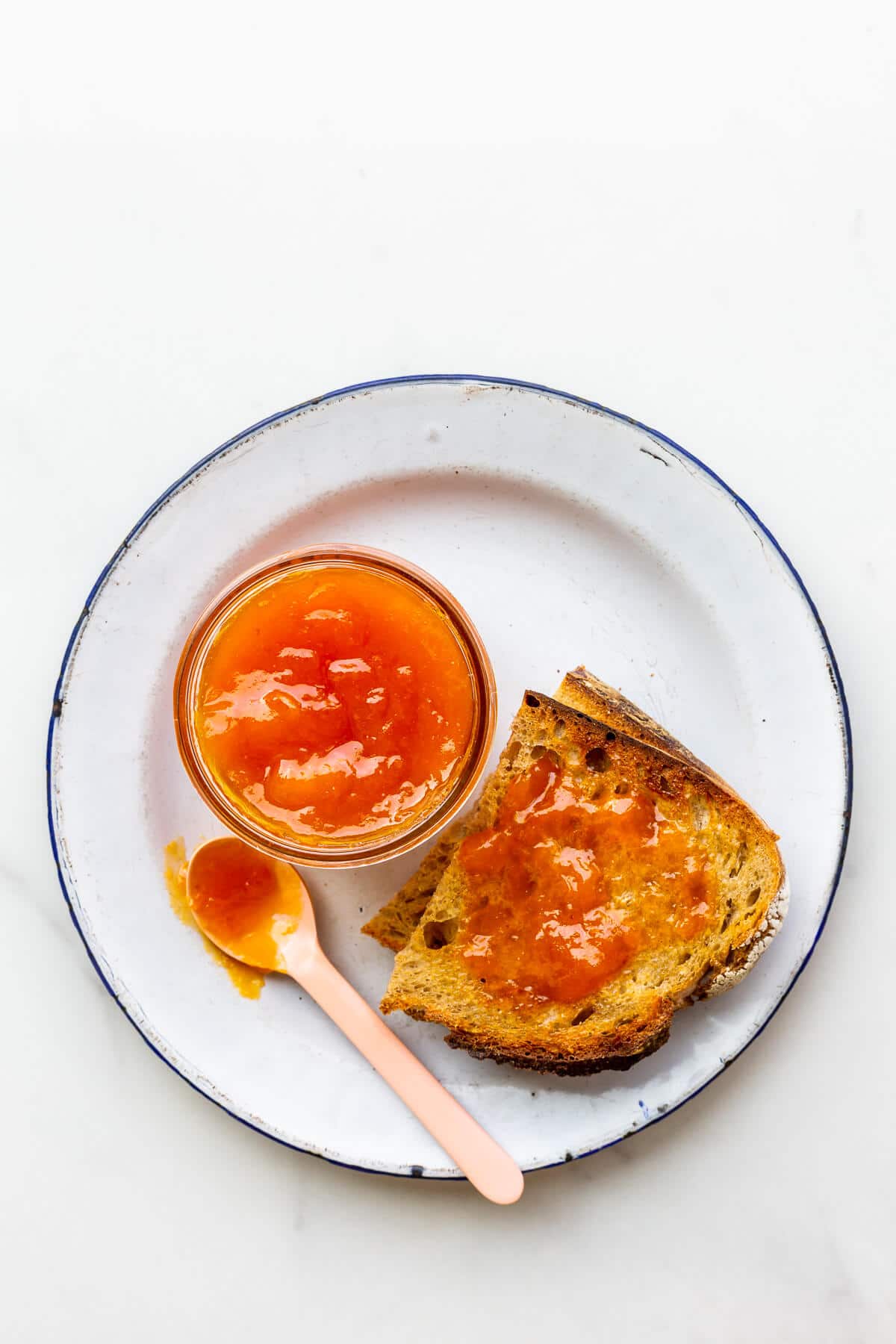 Apricot jam served with toast on a plate.