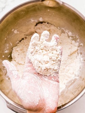Hand of flour and butter cut together for making scones.