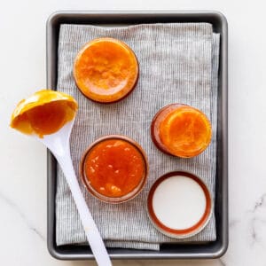 Transferring homemade apricot jam into jars to seal them.