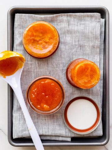 Transferring homemade apricot jam into jars to seal them.