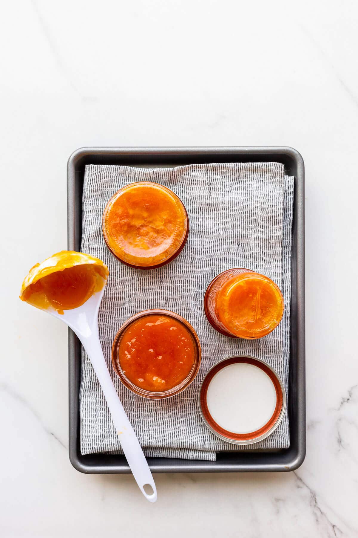 Transferring homemade apricot jam into jars to seal them.