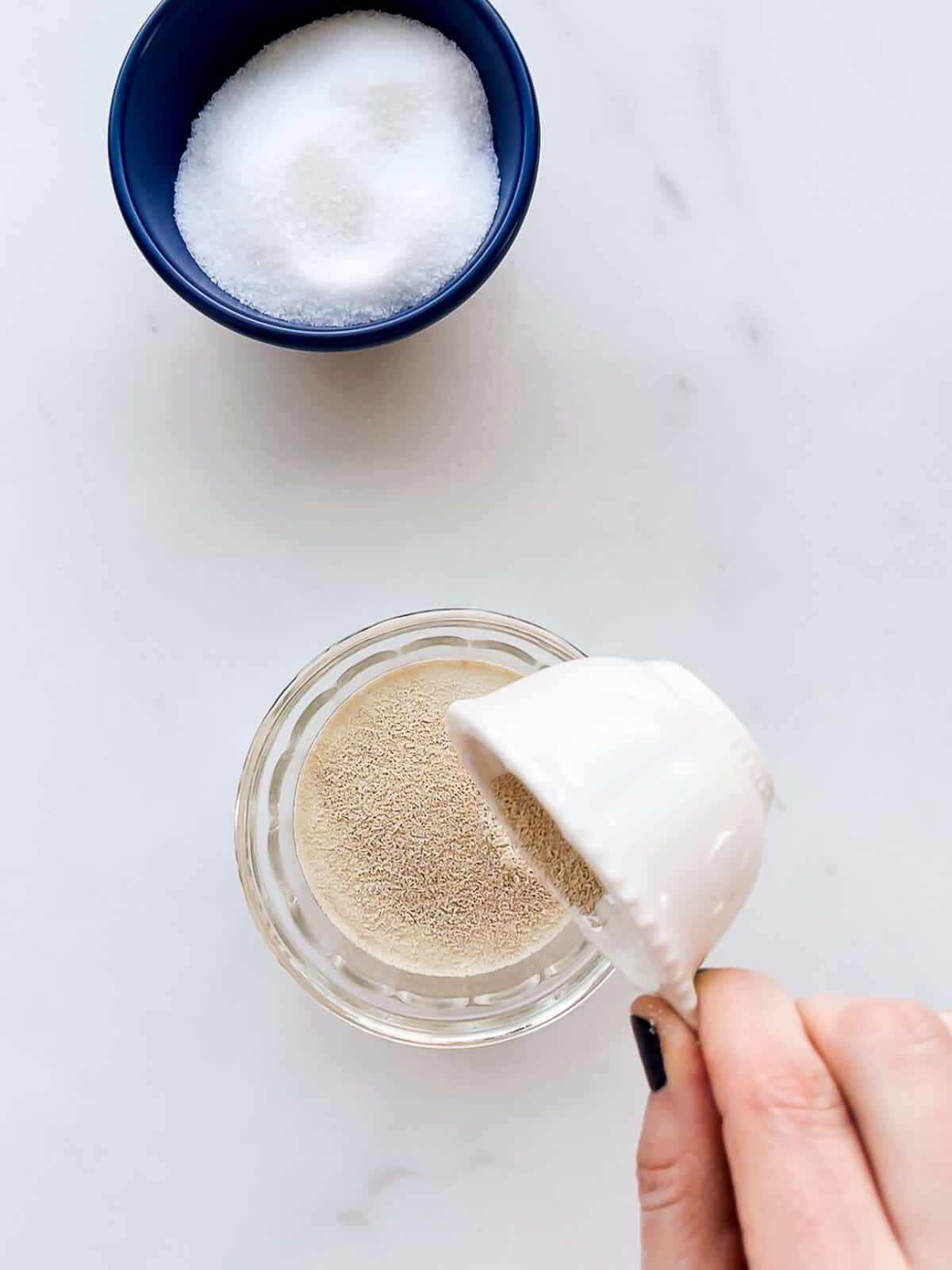 Dissolving yeast in a small bowl with water to bring it back to life before using it.