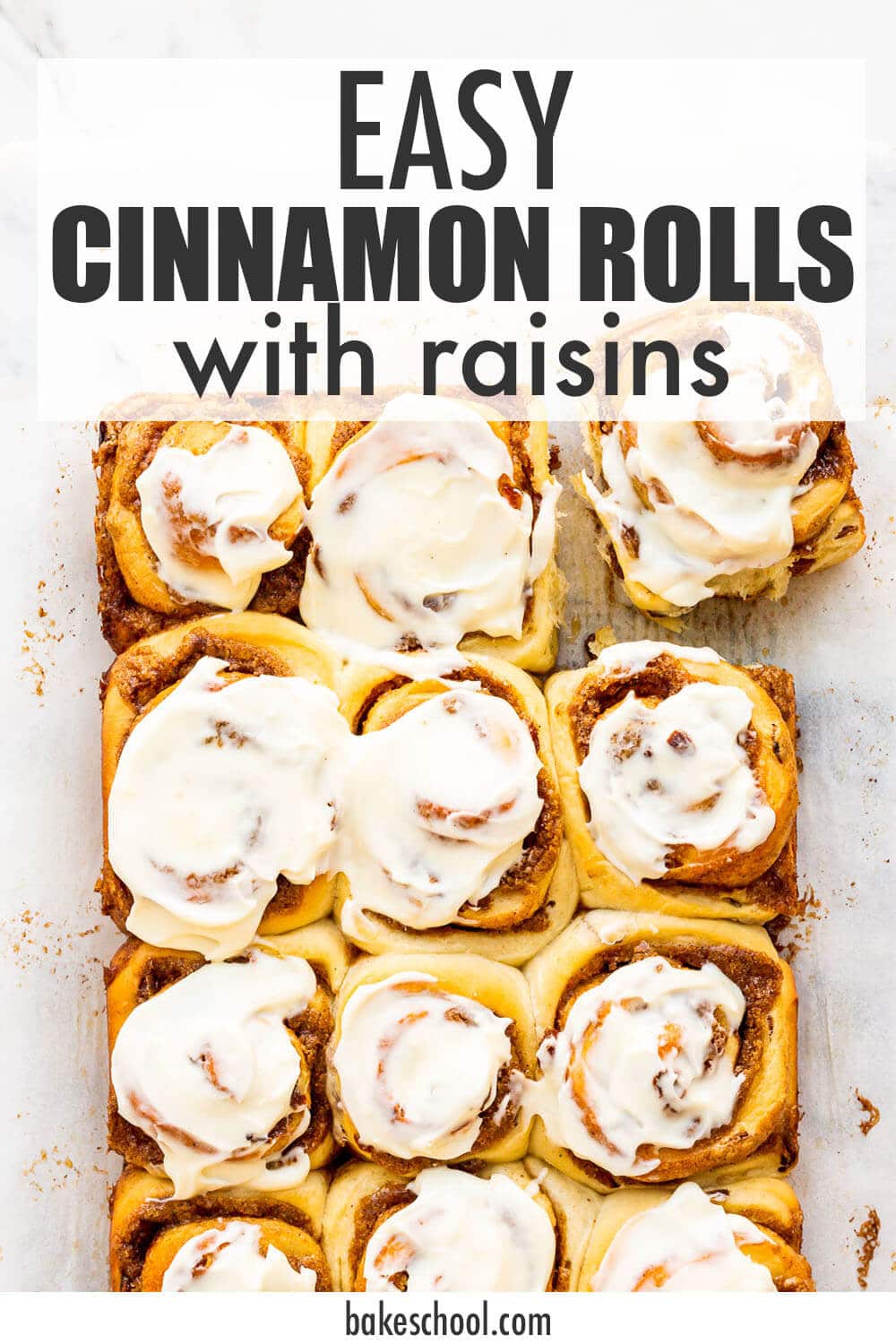 A dozen cinnamon rolls topped with cream cheese icing unmoulded and ready to eat.