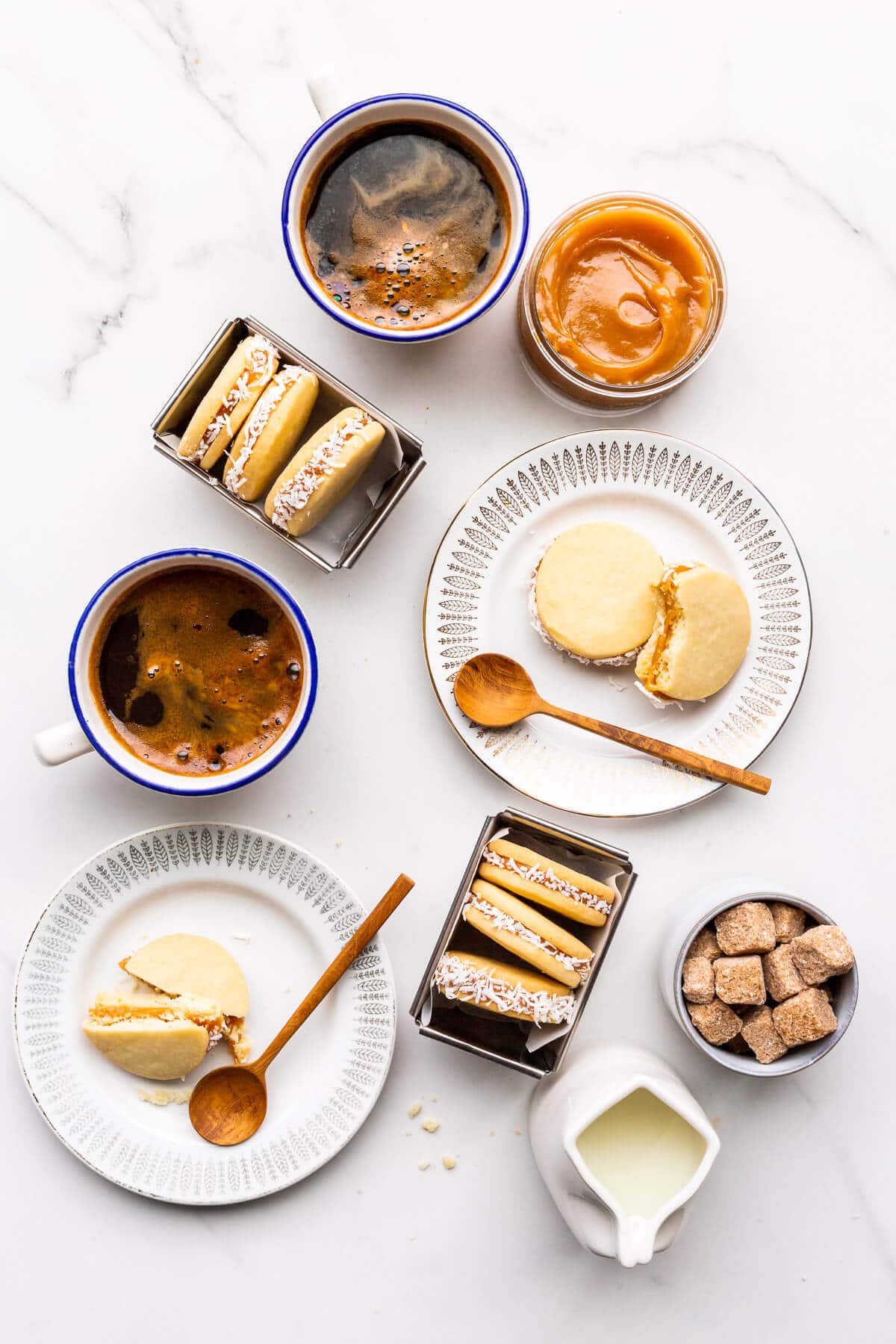 Alfajores sandwich cookies coated in coconut and served with coffee.