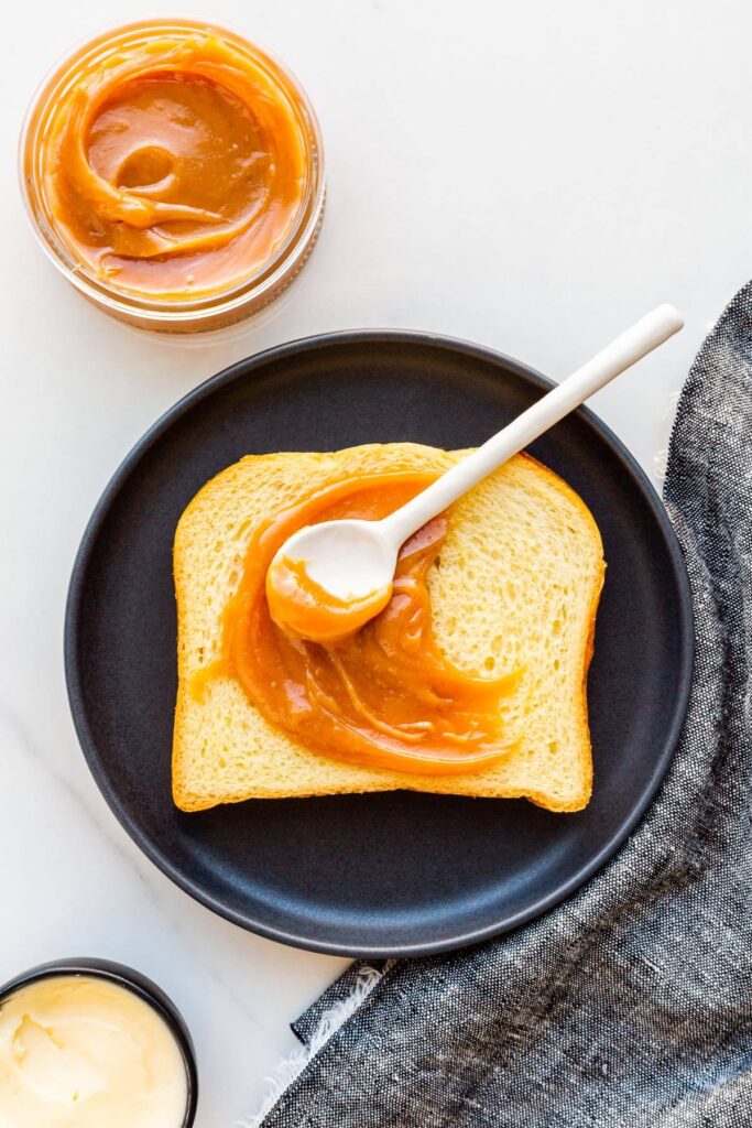 A slice of brioche with homemade dulce de leche smeared on it.