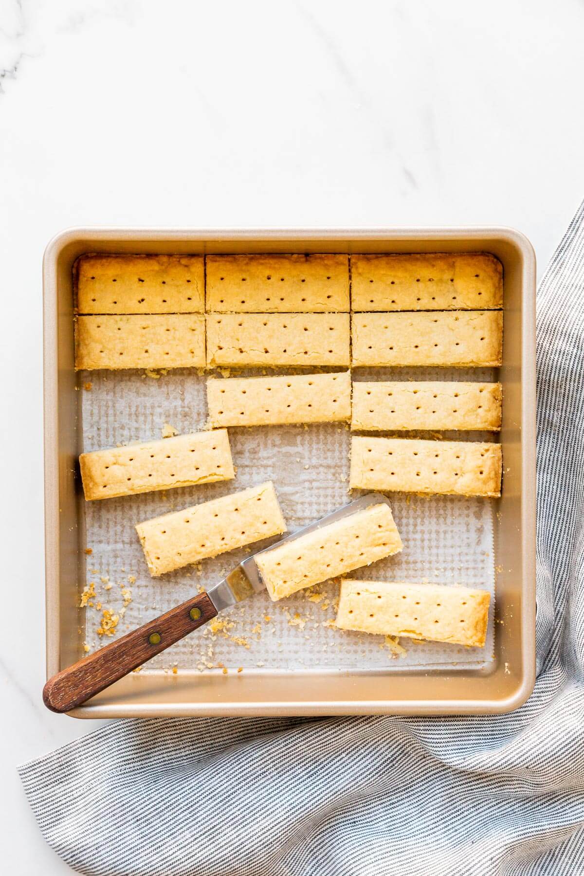 Shortbread cookies cut into sticks being served from the square pan they were baked in.