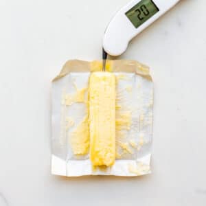 Taking the temperature of softened butter to show that it is the right temperature to make cookies with.