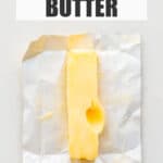 Softened butter with a deep thumbrint on the side to show the pliable texture that it has, which is perfect for baking cookies and cakes.