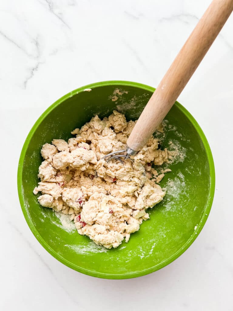 Working dough gently with a Danish dough whisk to make scones with rhubarb.