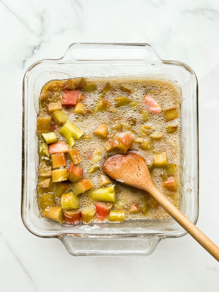 Stirring baking soda into roasted rhubarb to neutralize some of the astringent acid.