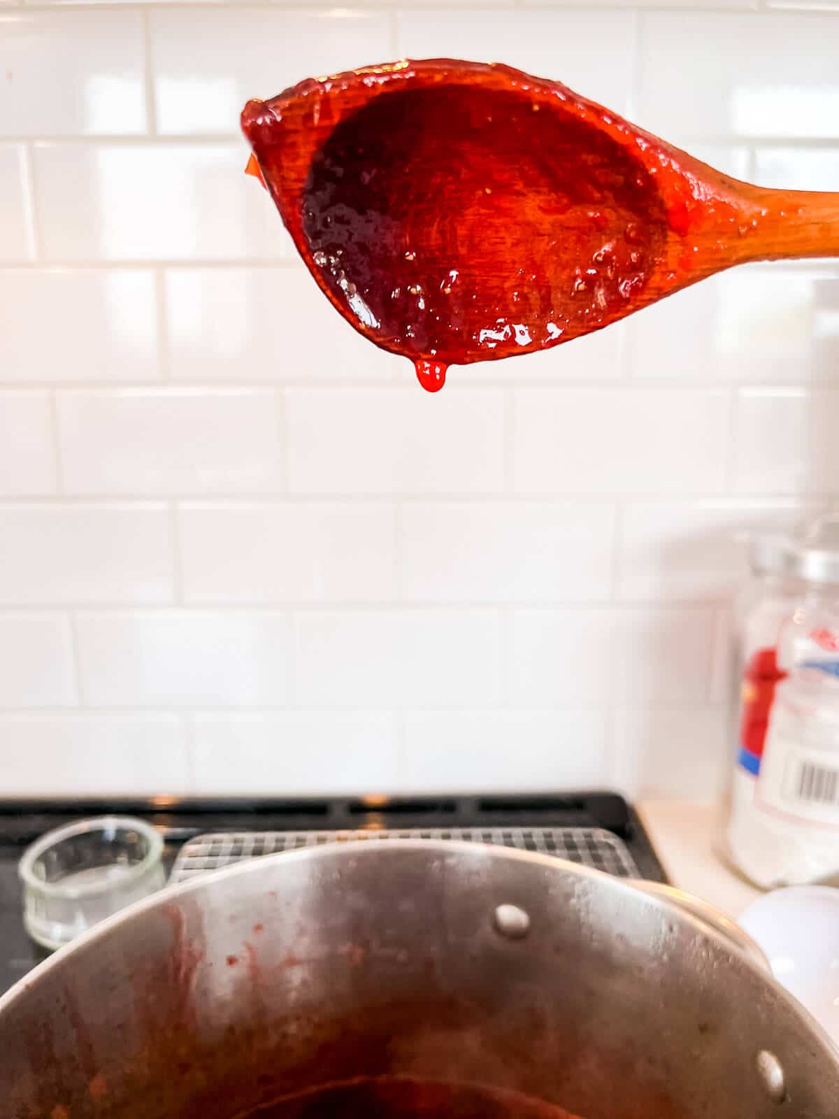 Lifting a wooden spoon of boiling jam above the pot to see if it clings to the spoon (also called sheeting), a sign that it has reached the setting point.