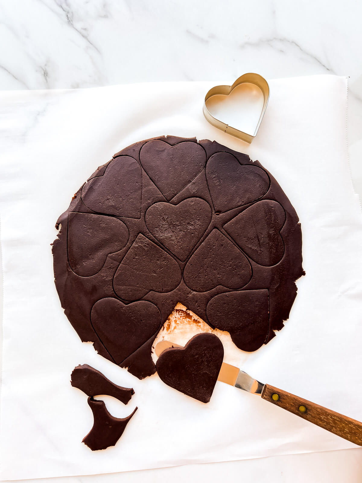 Transferring cutout cookies from parchment paper using a mini offset spatula