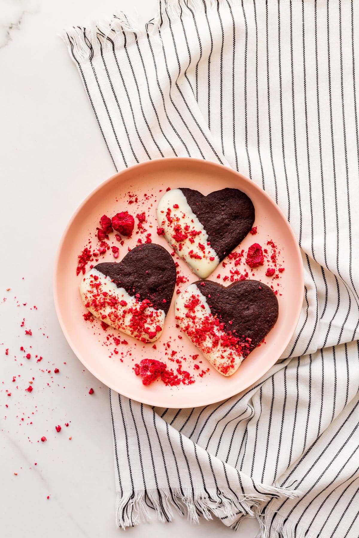 A plate of white chocolate-dipped chocolate shortbread cookies.