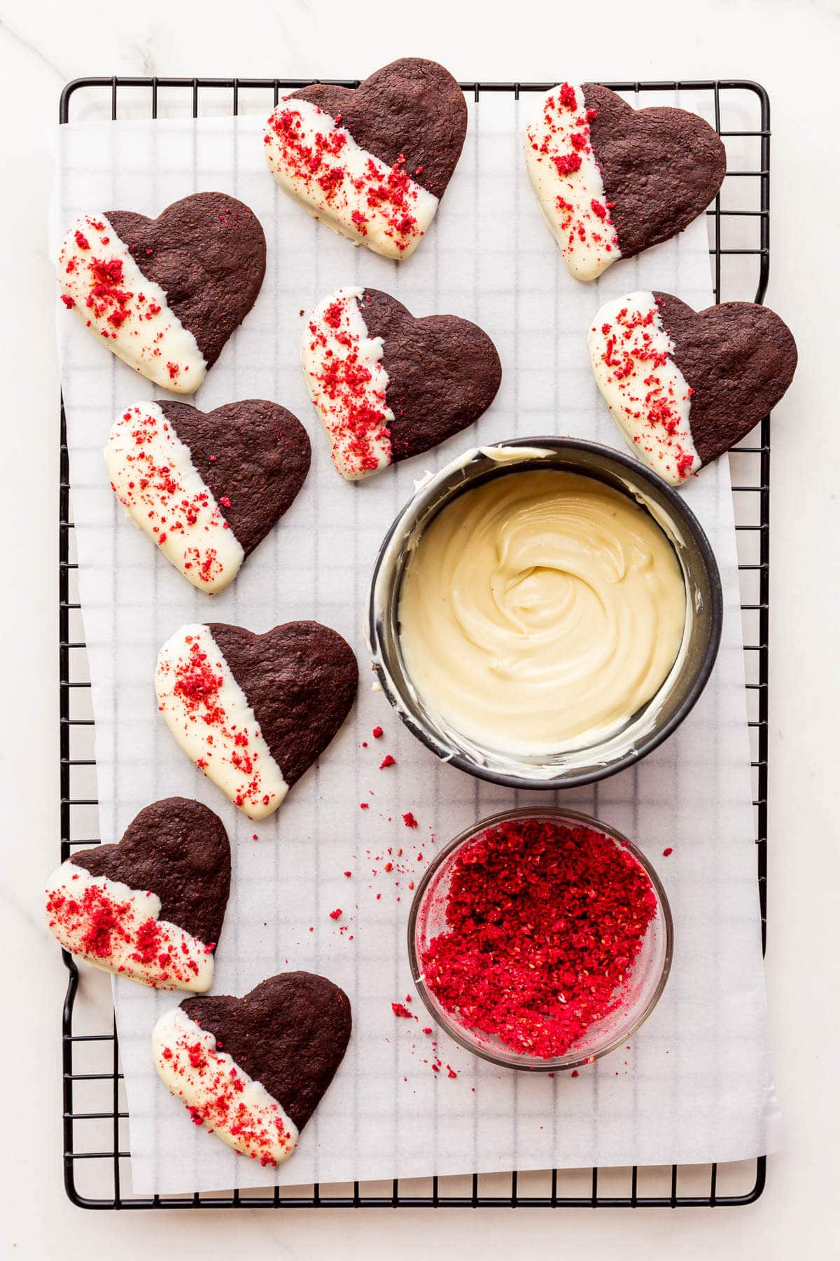 Dipping chocolate shortbread cookies in white chocolate and sprinkling with crushed freeze-dried raspberries.