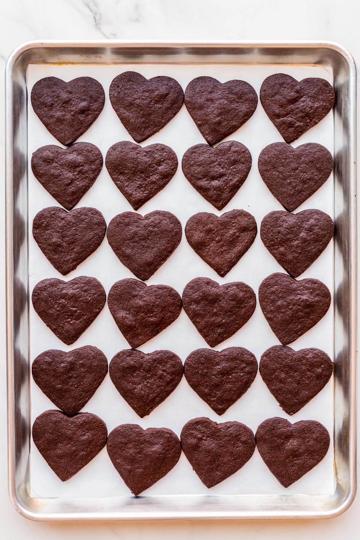 Chocolate shortbread cookies after baking on a sheet pan.