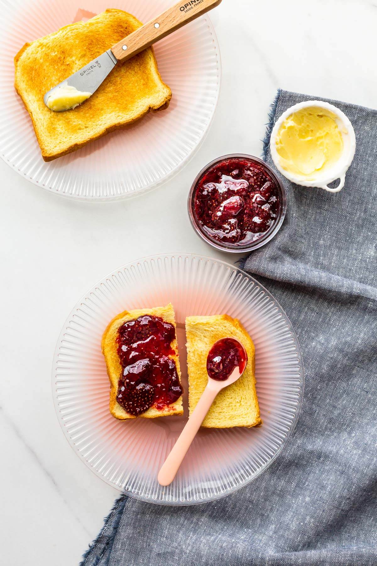 Smearing homemade strawberry jam on toast.