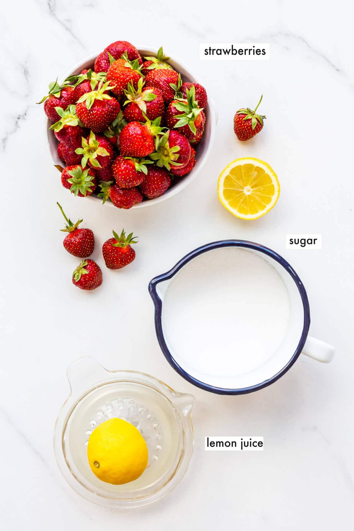 The three ingredients you need to make easy homemade strawberry jam: strawberries, sugar, and lemon juice.