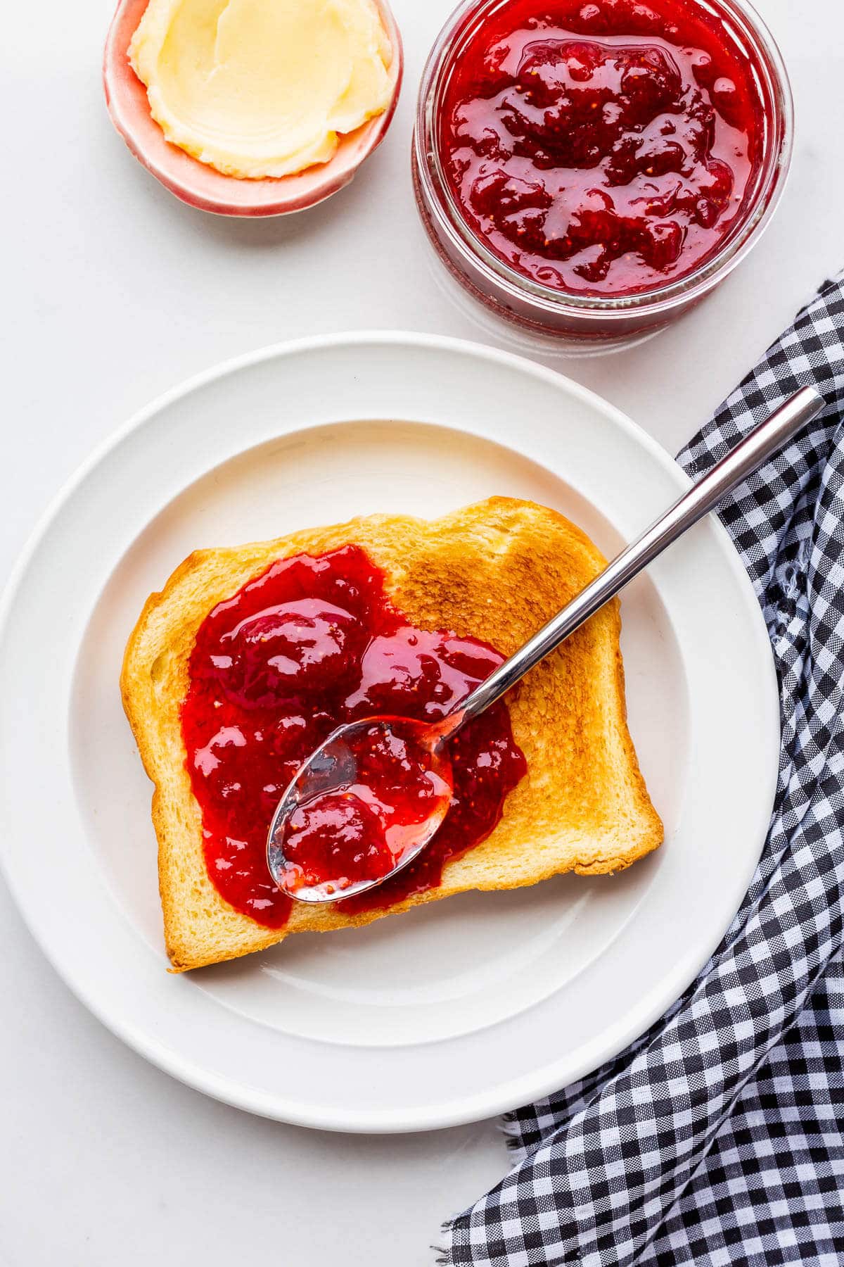 A piece of toast topped with strawberry jam with rhubarb.