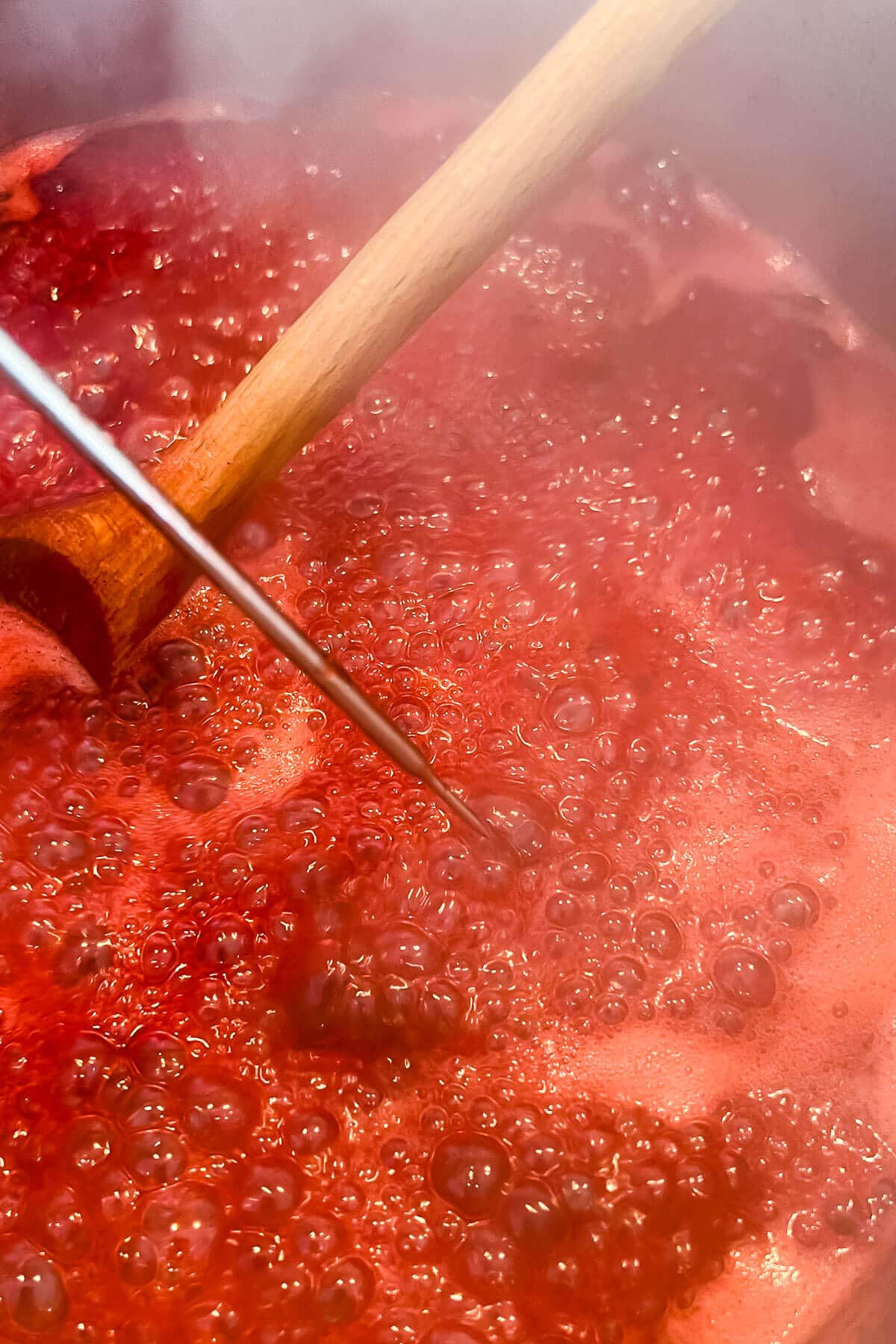 Boiling jam that is still runny with lots of tiny, volatile bubbles on the surface.