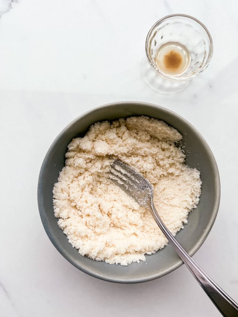 Mixing vanilla extract with granulated sugar to make a quick vanilla sugar.